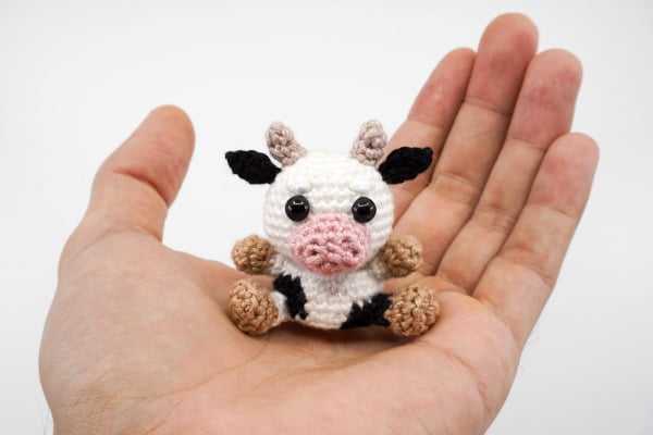 Tiny crochet cow with horns.