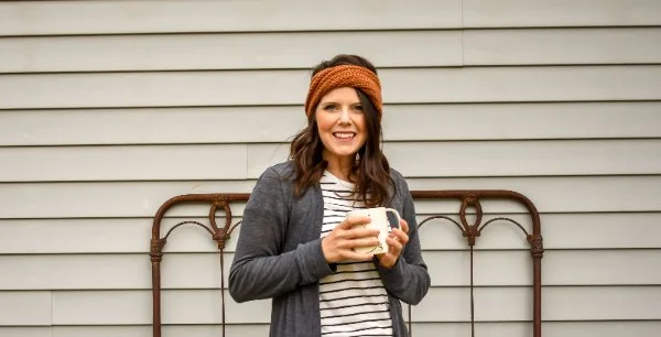 Woman waearing twist crochet headband.