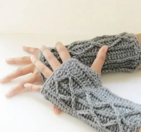 Person wearing faux cable crochet fingerless mitts.