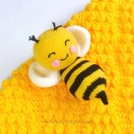 Smiling crochet bee lying on his back.