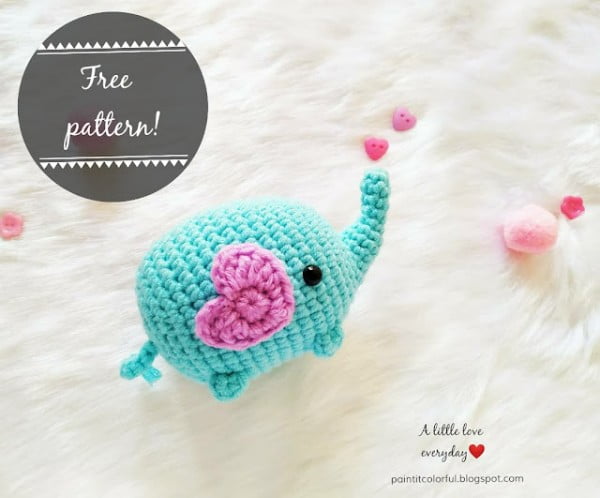 Bright blue amigurumi elephant with a pink love heart applique.