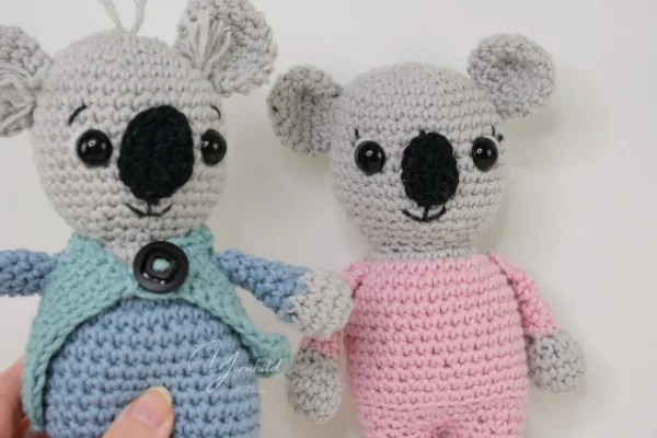 Two crochet koalas in clothes.