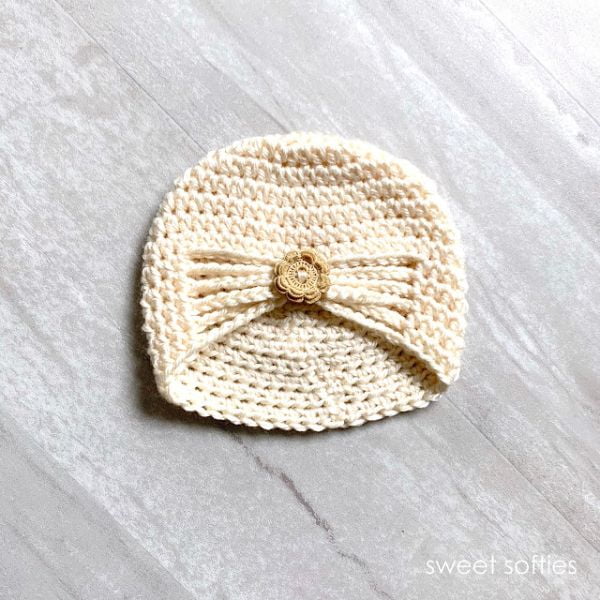 Crocheted baby turban with button detail.