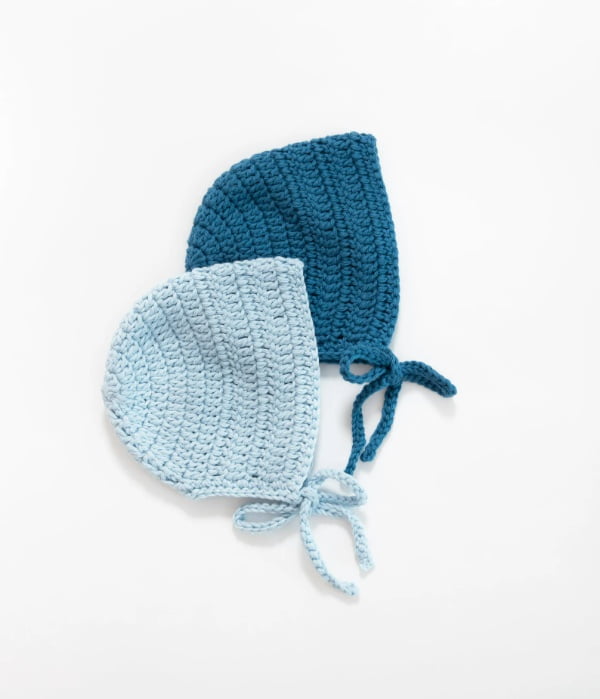 Two blue crochet baby bonnets.