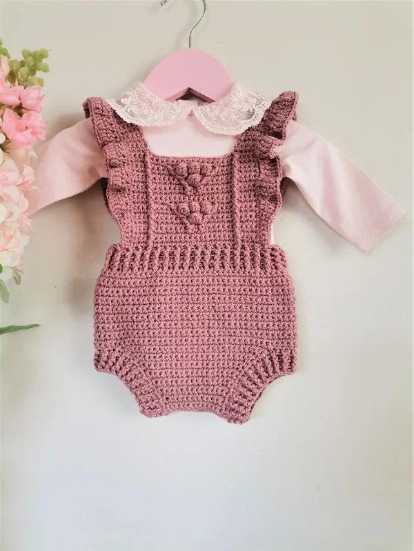 Pink crochet baby romper with ruffles.