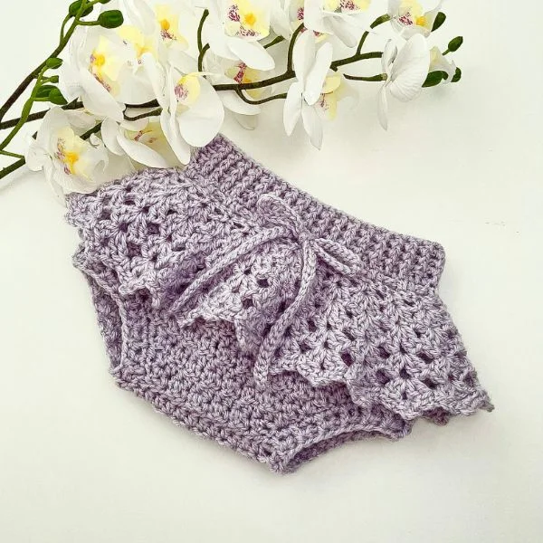 Lavender crochet baby bloomers with a lacy frill.