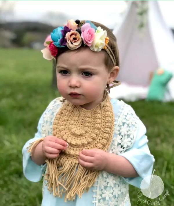 Toddler wearing a boho-style crochet baby bib.