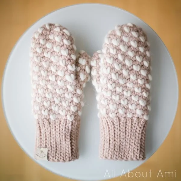 Pink and white thrummed crochet mittens.
