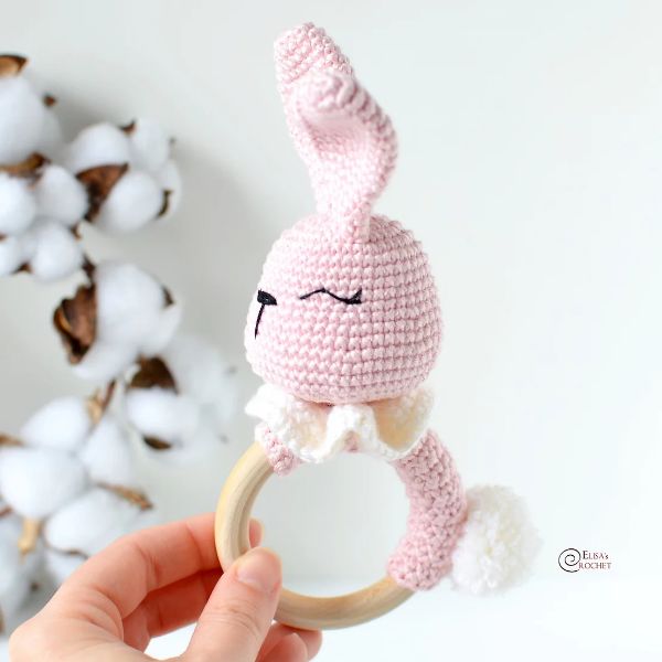 Crocheted pink bunny teething ring with fluffy tail.