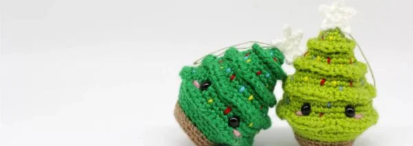 Two crocheted Christmas tree ornaments.