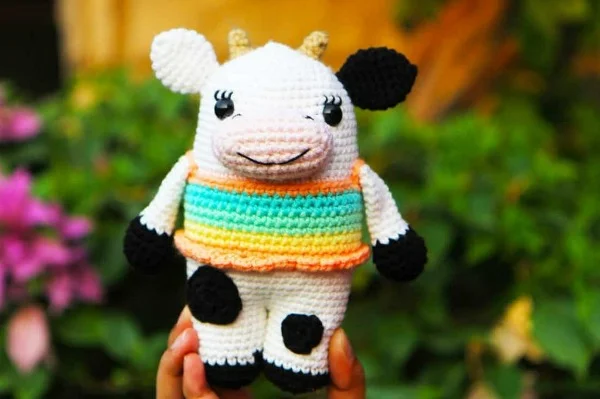Crochet cow with a stripy top.