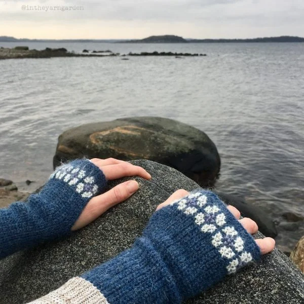 Person wearing crochet wristwarmers by the water.