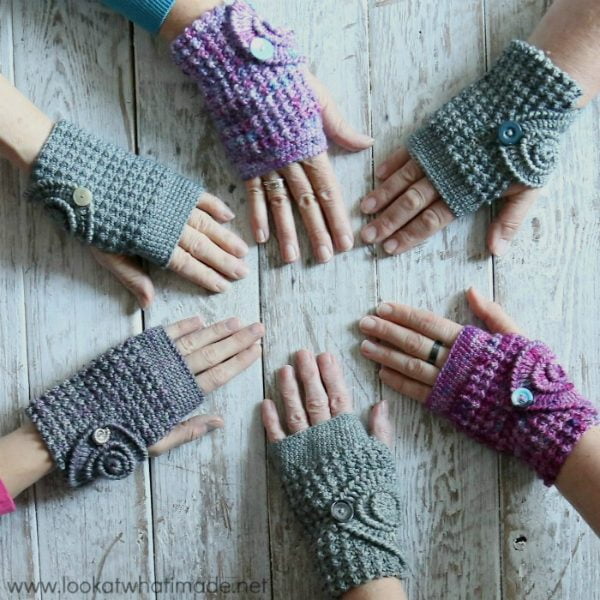 Six hands wearing crocheted wrist warmers.