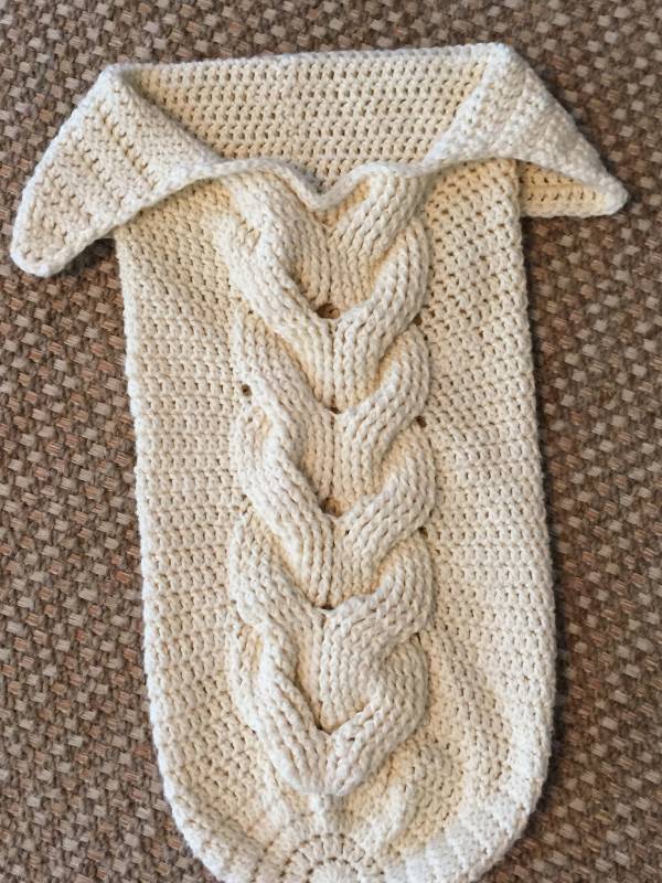 Crochet baby cocoon with cable detail.
