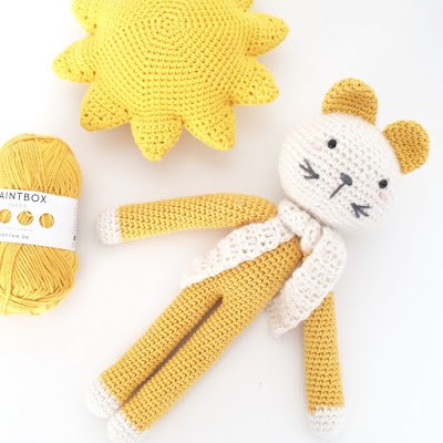 Yellow and white crochet cat and yellow yarn ball.