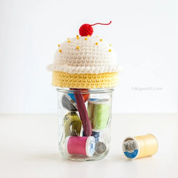 Mason jar sewing kit with crochet cupcake pin cushion on top.