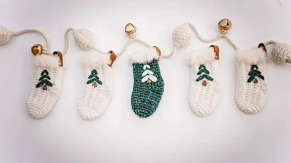Five green and white crochet Christmas stockings.