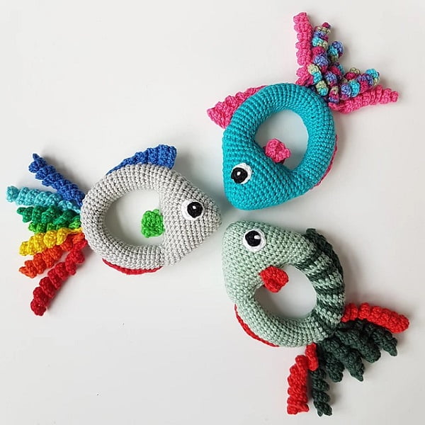 Three brightly colored crochet fish rattles.