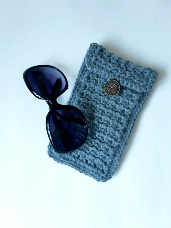 Blue crochet glasses case and a paor of sunglasses.