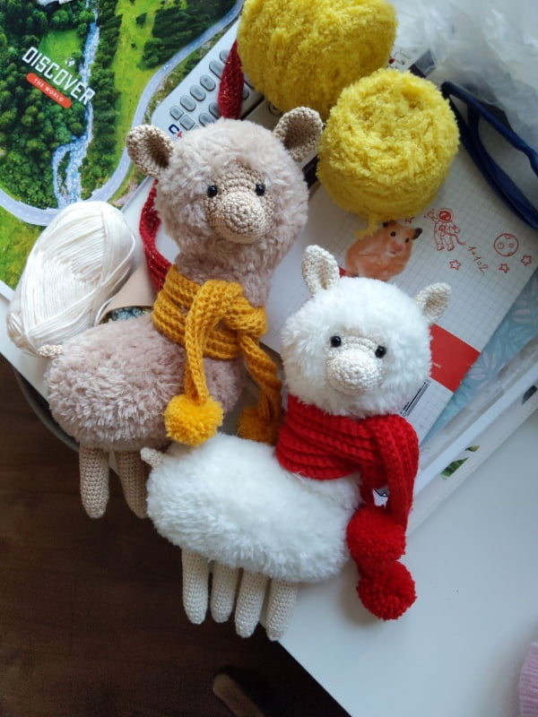 Fluffy crochet llamas/alpacs wearing scarves.