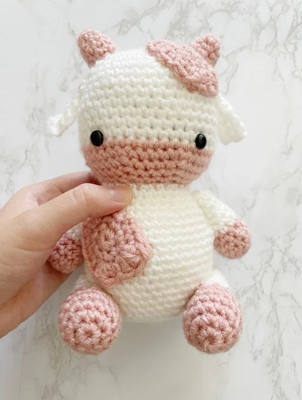 Sweet pink and white strawberry cow amigurumi.
