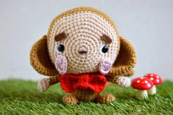 Amigurumi crochet monkey wearing a red bow tie.