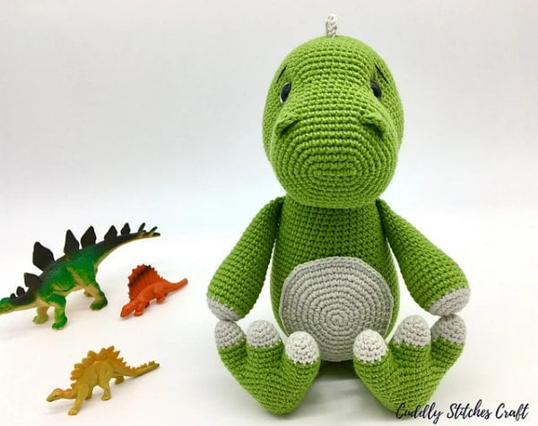 Green crochet dinodaur plushie.