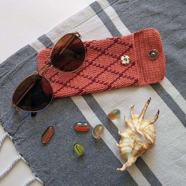 Diamond pattern colourwork sunglasses case with shells and glass beads.