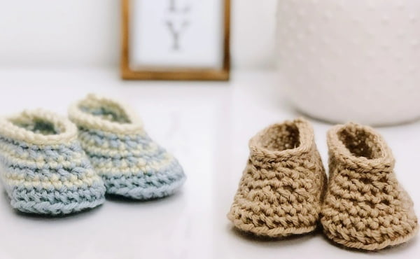 Two pairs of crocheted baby booties.