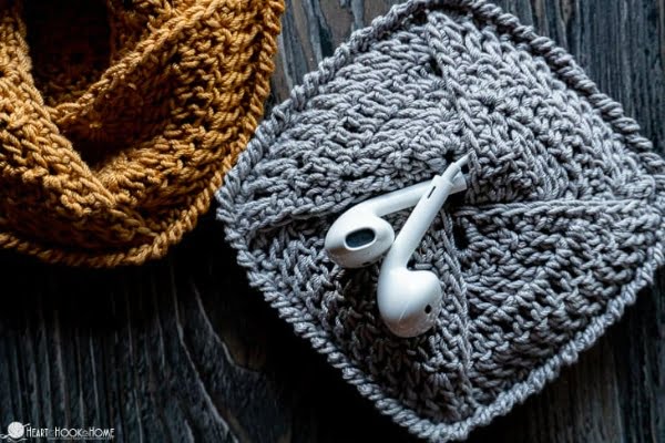 Grey crochet case holding earbuds.