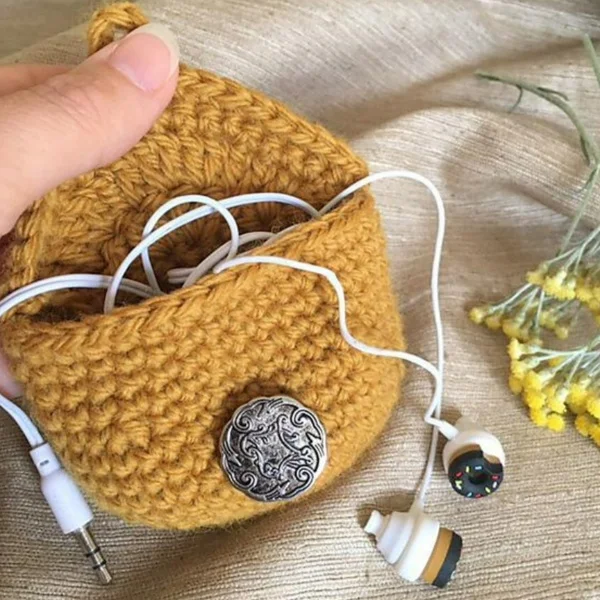 Crochet purse holding earbuds.