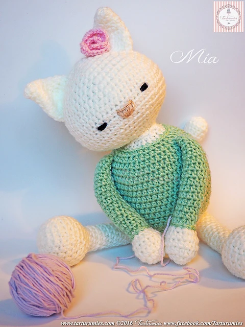 White crochet cat wearing a green sweater.