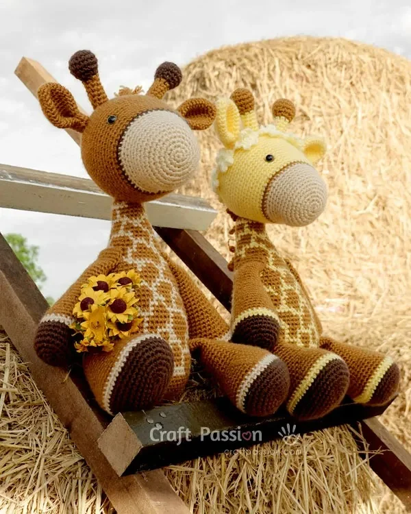 Two crochet giraffe amigurumi sitting on a ladder.