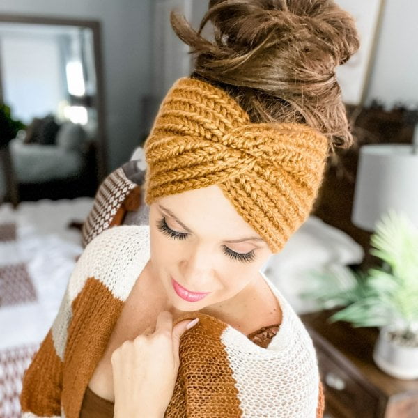 Woman wearing wide crochet ear warmer with twist design.