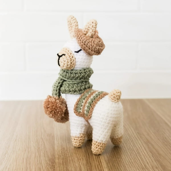 Crochet Llama amigurumi wearing a hat and scarf.