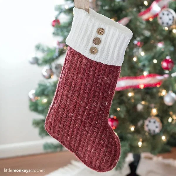 Red and white crochet Christmas stocking with buttons on cuff.