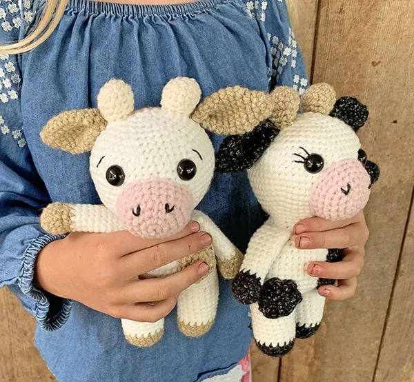 Two crochet cow softies.