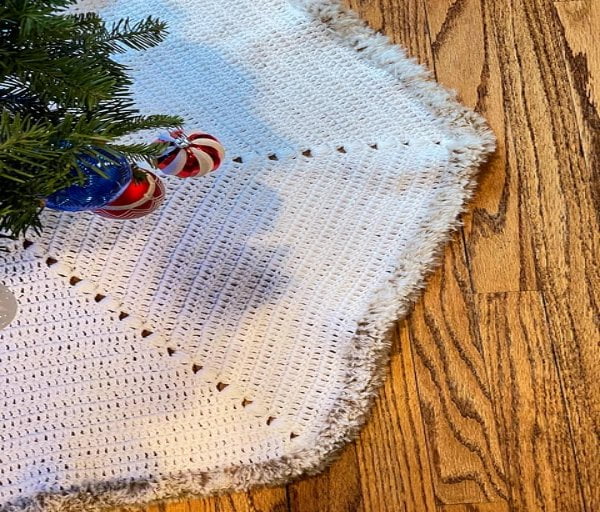 Bobble stitch crochet holiday tree skirt with faux fur trim.