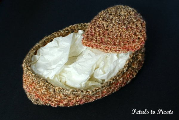 A crochet baby cocoon and matching baby hat.
