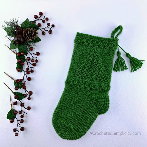 Green crochet Christmas sotkcing with Christmas tree pattern.