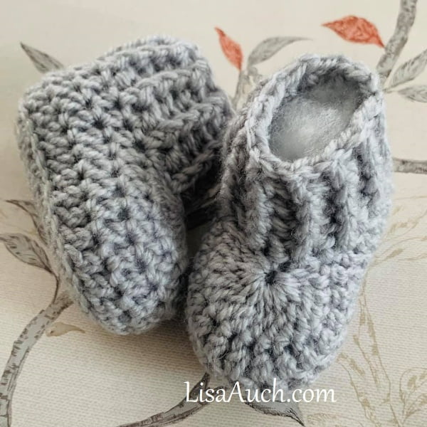 Crochet baby booties with ribbed cuff.