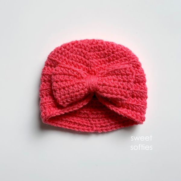 A red crochet baby turban with a bow.