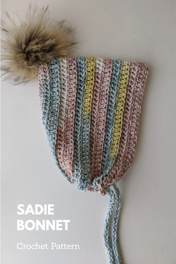 Crochet bonnet with fur pom pom.