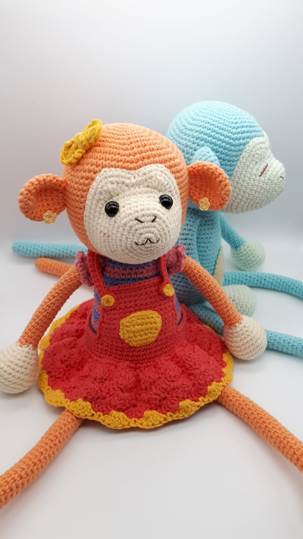 Amigurumi crochet monkey in a red dress.