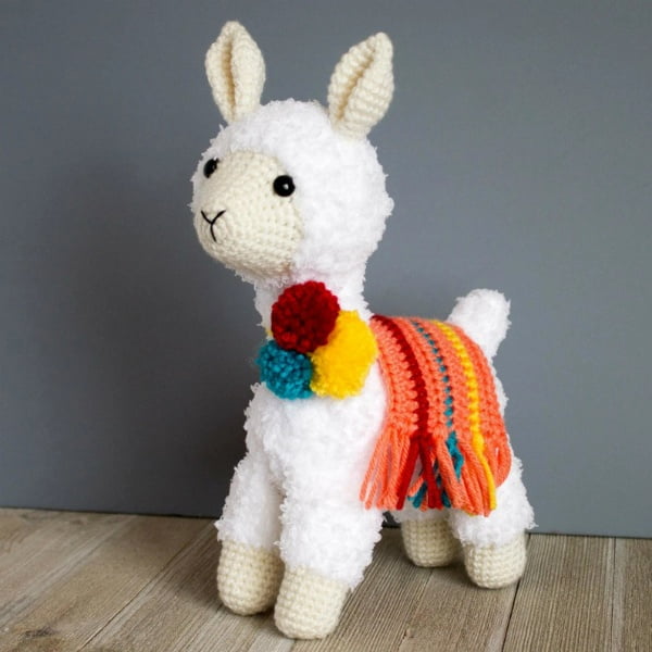 Crochet llama toy with colorful saddle blanket.