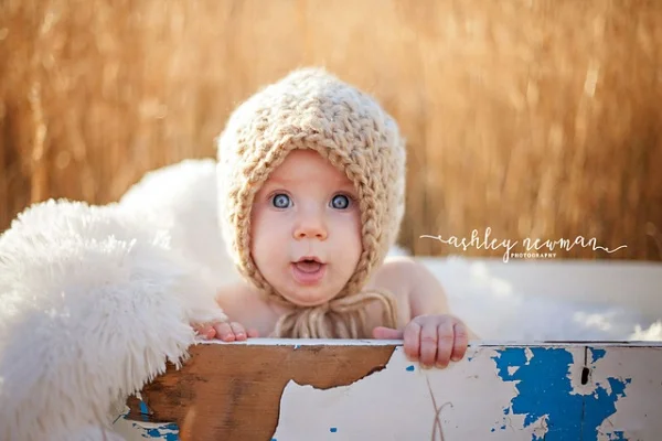 Baby wearing a crochet baby bonnet.