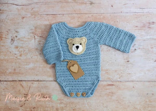 Crochet long-sleeved baby romper with teddy bear applique.