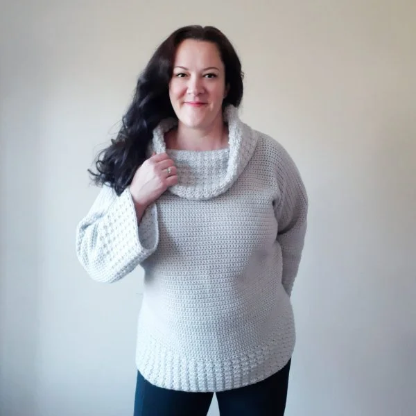 Woman wearing crochet cowl neck sweater.
