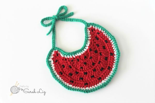 Crochet baby bib that looks like a slice of watermelon.