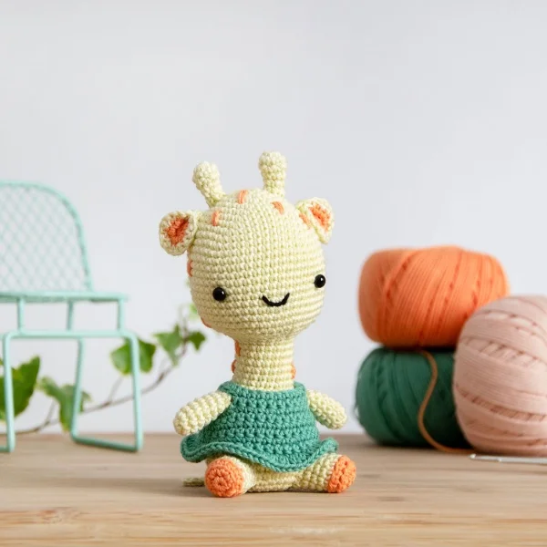 Crochet giraffe wearing a green dress.